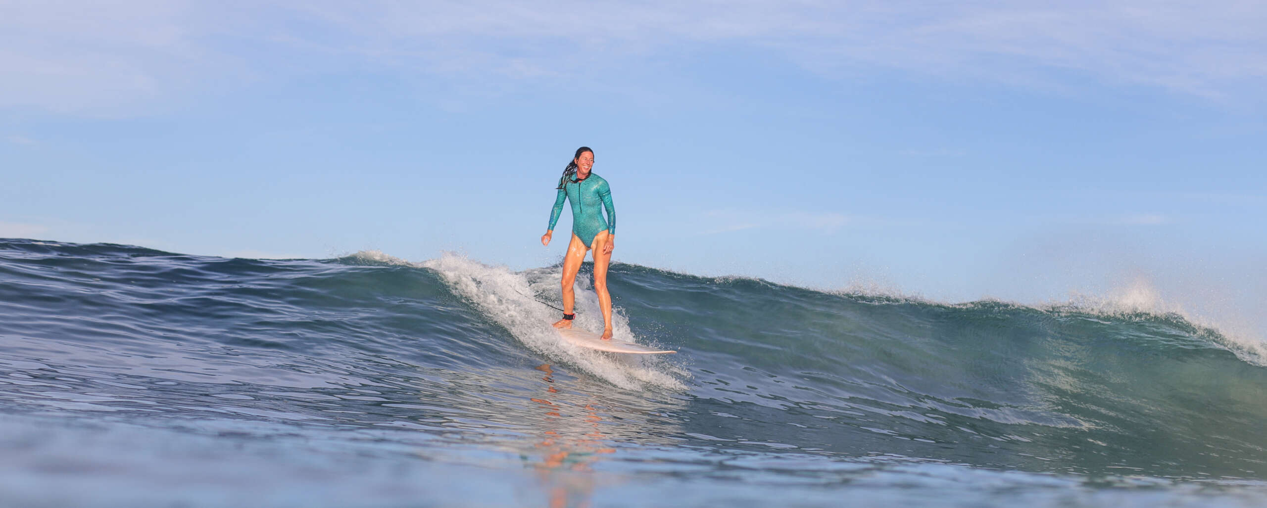 Surf coach guiding a student into a wave in Cornwall